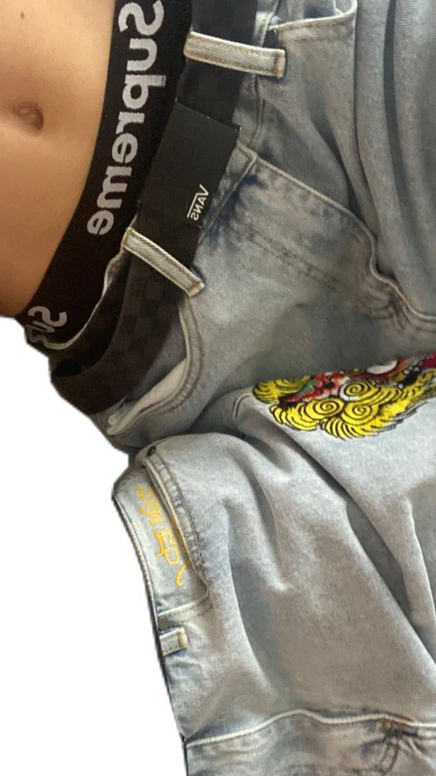 A close up of a person wearing a hoodie with a tattoo on it.