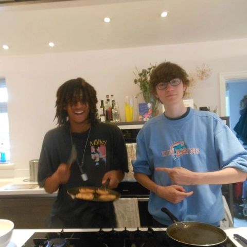 A group of young men standing next to each other in a kitchen.