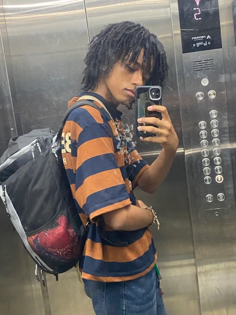 A young boy taking a picture of himself in a mirror.