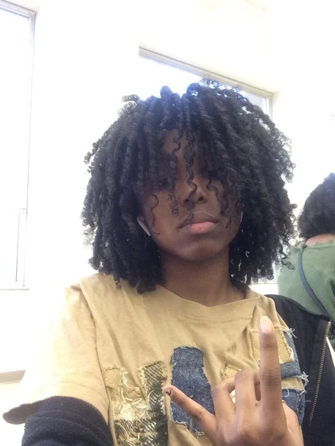 A man with curly hair is posing for a picture.