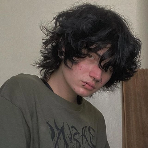 A young man with a nose piercing on his nose.