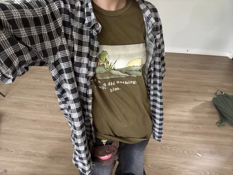 A woman wearing a green shirt with a picture of a frog on it.