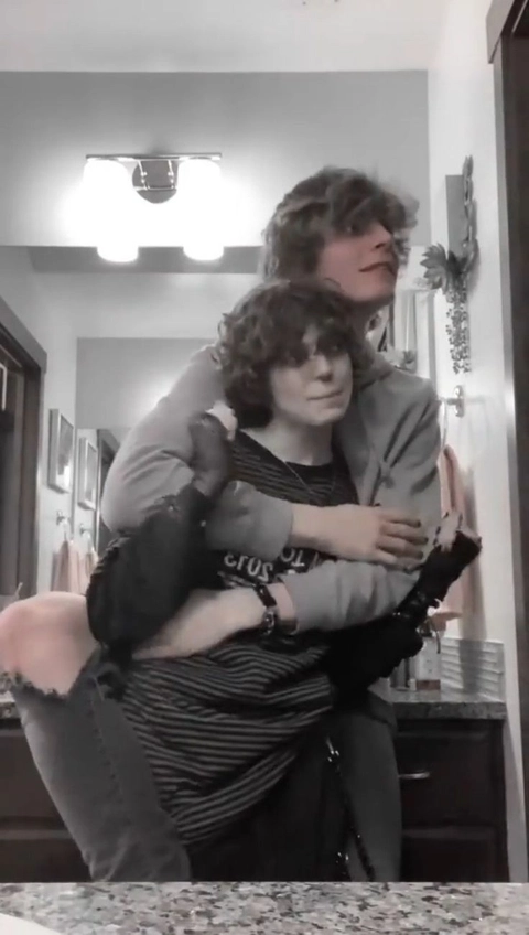 A man and a woman sitting on top of a counter.