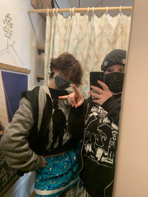 A couple of people that are standing in front of a mirror.