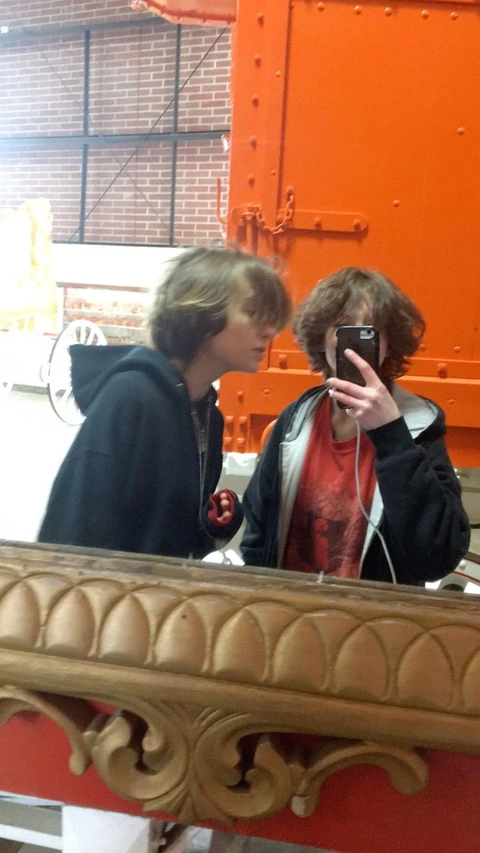 A reflection of a man taking a picture of himself in a mirror.