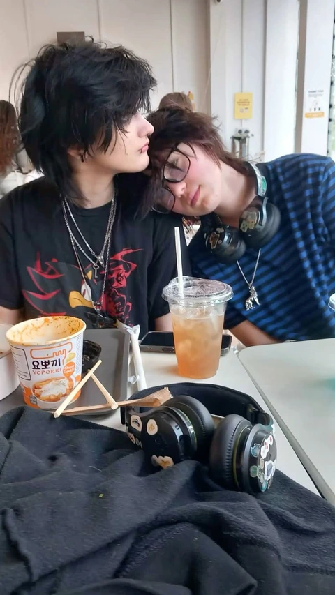 A couple of people sitting at a table with headphones on.