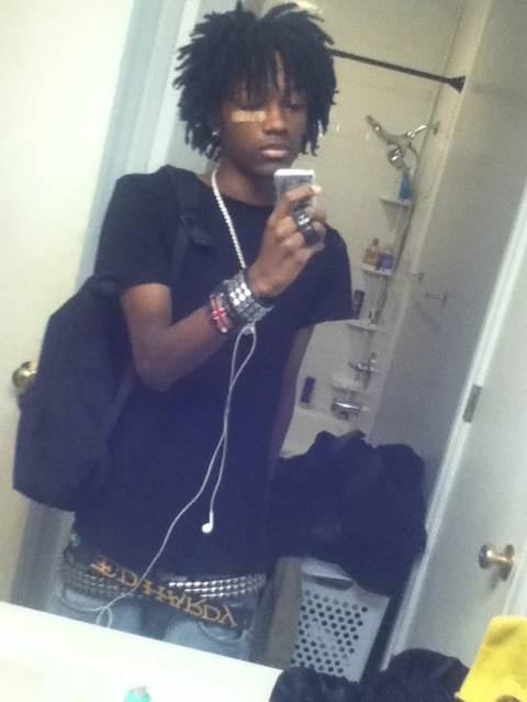 A young man taking a selfie in a bathroom mirror.