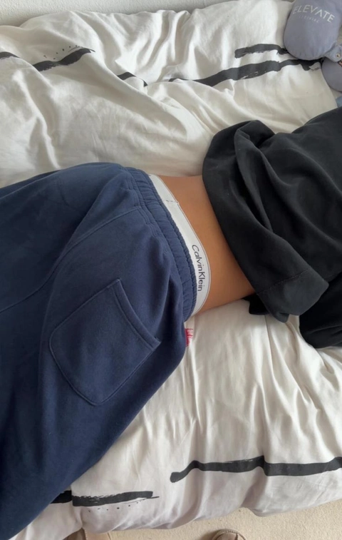 A person laying on top of a bed covered in blankets.