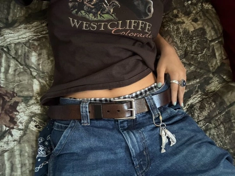 A woman wearing a brown shirt and blue jeans.