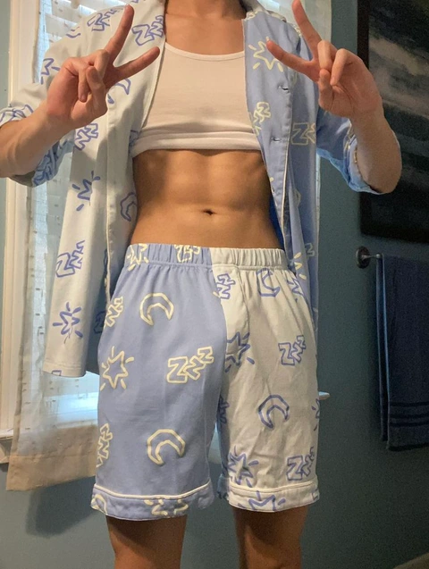 A woman in a blue and white outfit is making a peace sign.
