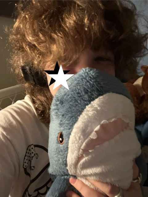 A person holding a stuffed animal in their hands.