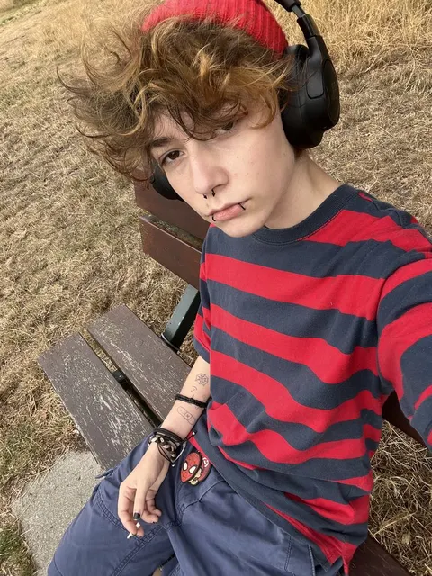 A young boy with headphones sitting on a bench.