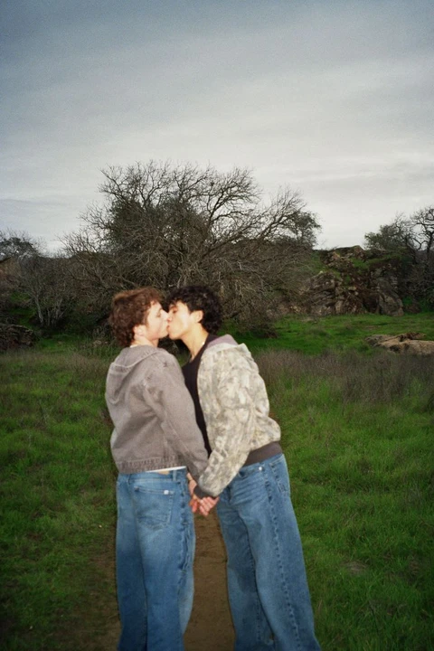 A couple of people standing next to each other in a field.