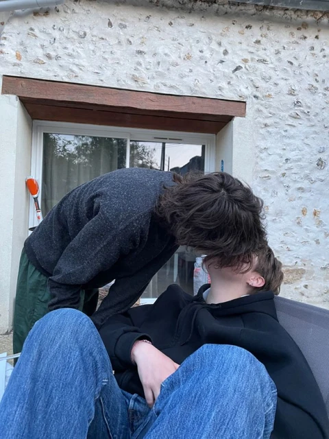 A couple of people that are sitting on a bench.