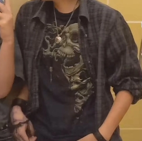 A man wearing a black shirt with a skull on it.