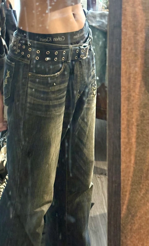 A pair of jeans with studded straps on them.