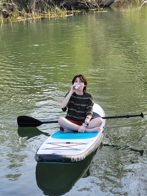 A man sitting on top of a boat in the water.