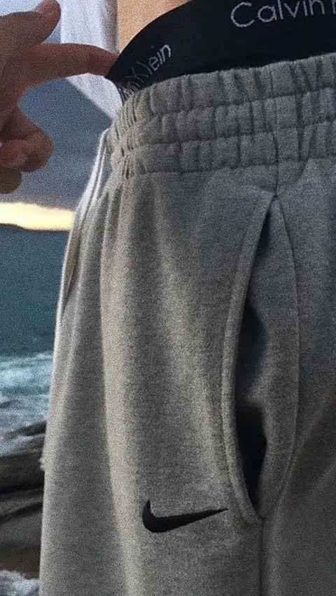 a person holding a pair of pants with a nike logo on it