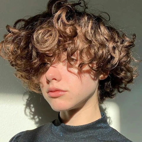 A woman with curly hair is shown in a photo.