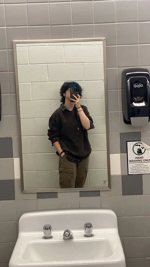 A man taking a picture of himself in a bathroom mirror.