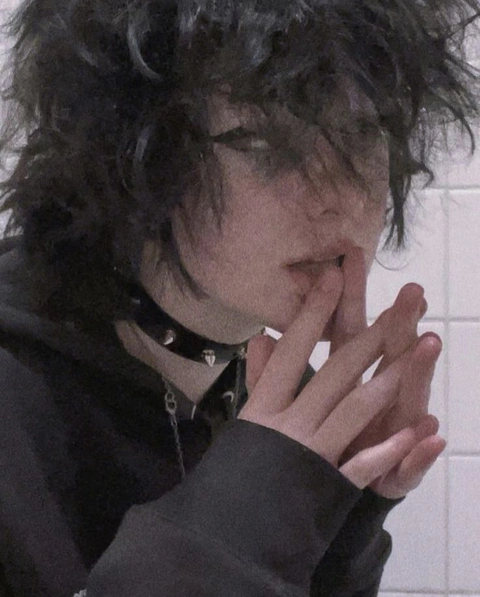 A man with black hair covering his face with his hands.