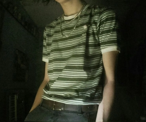A man wearing a green and white striped shirt.