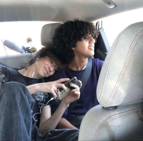 A group of people sitting in the back seat of a car.