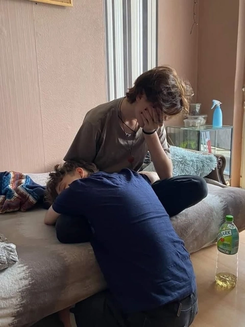A group of people laying on top of a couch.