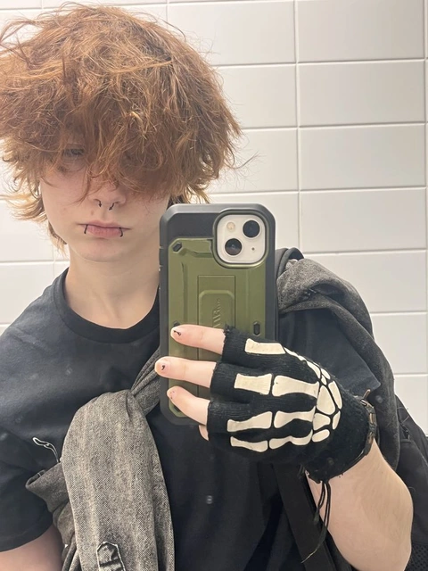 A person holding a cell phone with a skeleton hand on it.