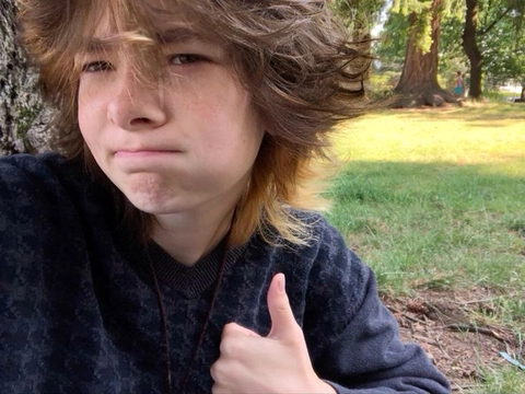 A young man with long hair and a black sweater.