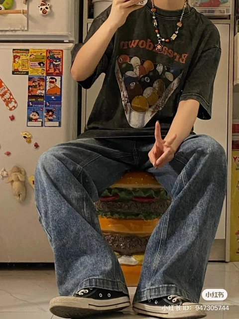 A man sitting on top of a chair holding a cell phone.