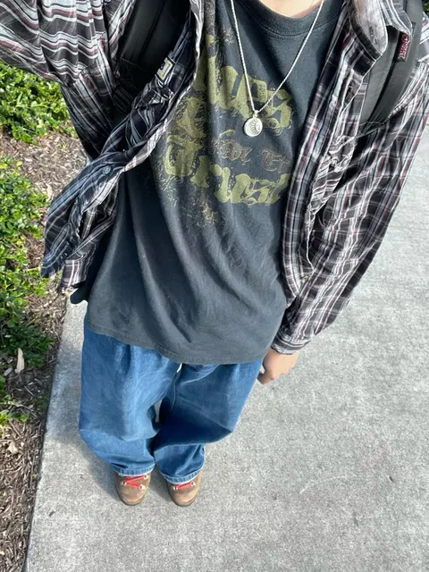 A man wearing a black shirt and blue jeans.