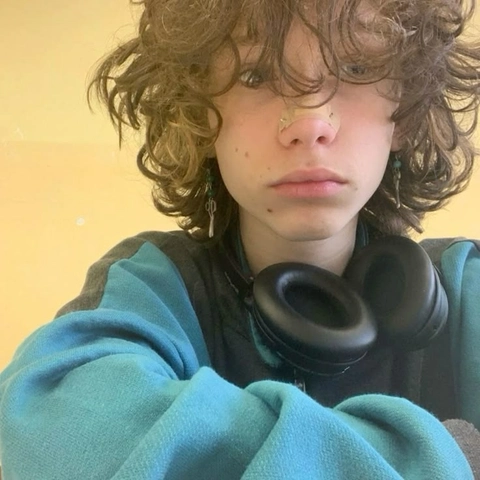 A young man with curly hair wearing a blue shirt.