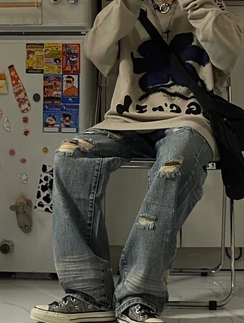 A man sitting on top of a chair in front of a refrigerator.