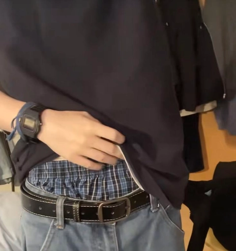 A mannequin wearing a black shirt and a plaid skirt.