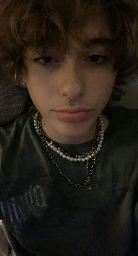 A young man with a nose piercing and a chain around his neck.