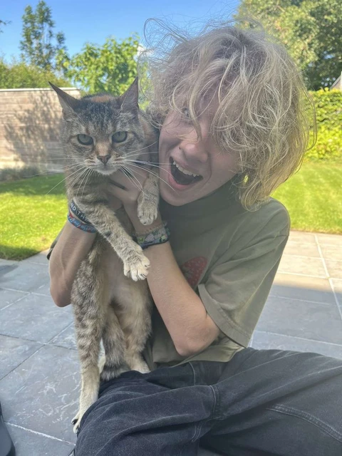A woman holding a cat in her arms.
