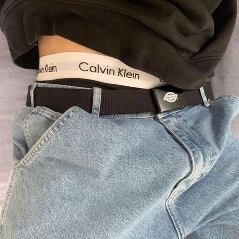 A close up of a person wearing a black shirt and jeans.
